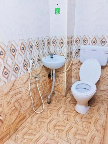 a bathroom with a toilet and a sink at Hotel Mtc Guest House in Chennai