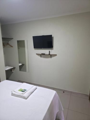 a white room with a tv on the wall at Pousada Alvorada in Engenheiro Coelho