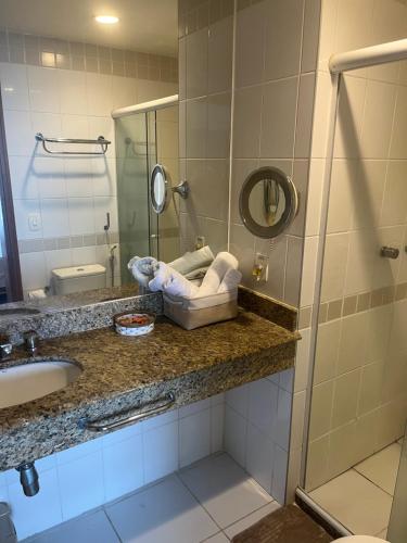 a bathroom with a sink and a mirror at Flat Tropical Hotel Com Varanda Vista Espetacular in Manaus