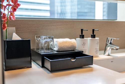 a bathroom with a sink with a towel in a black box at Pan Pacific Serviced Suites Beach Road, Singapore in Singapore