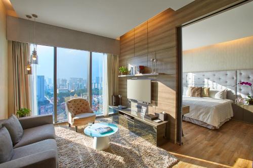 a bedroom with a bed and a living room at Pan Pacific Serviced Suites Beach Road, Singapore in Singapore