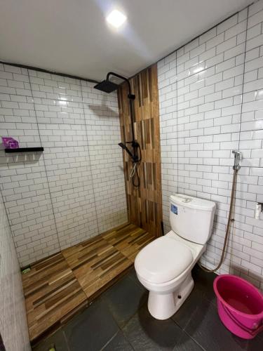 a bathroom with a toilet and a bath tub at Cottage Linggayoni Dieng in Diyeng
