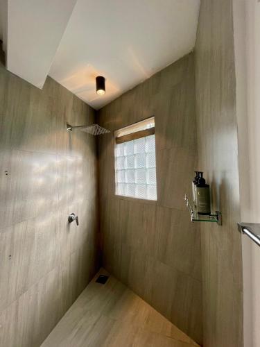 a small bathroom with a window and wooden floor at Lido Dikwella in Dickwella