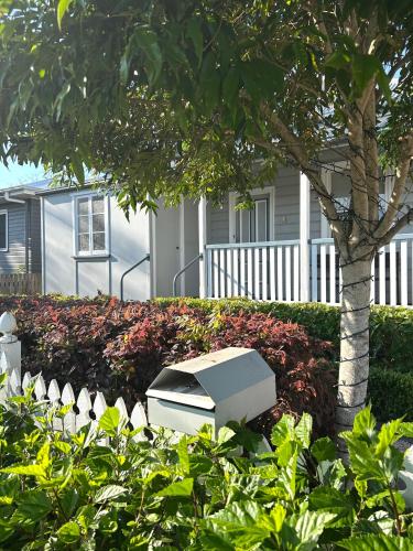 a computer monitor sitting in a garden next to a tree at Eton Cottage - Central Boutique Stay in Toowoomba