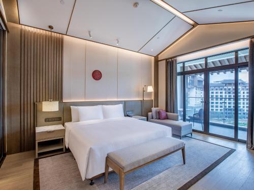 a bedroom with a large white bed and a window at Steigenberger Hotel Chongqing in Chongqing