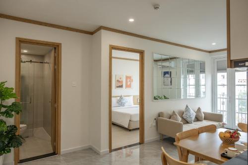 a living room with a couch and a bedroom at KOA Apart Hotel Phu Quoc in Phú Quốc