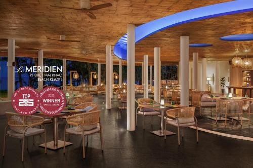 a dining area with tables and chairs in a restaurant at Le Meridien Phuket Mai Khao Beach Resort in Mai Khao Beach