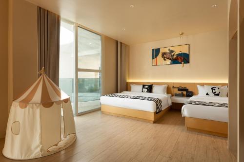 a hotel room with two beds and a window at Langying Intelligent Guesthouse in Sanya