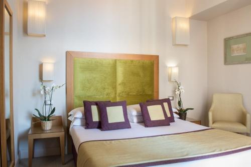 a bedroom with a large bed with purple pillows at Hotel Perseo in Florence