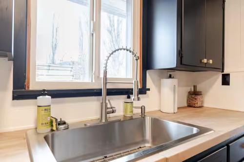 a kitchen with a stainless steel sink and a window at Uptown Estates - Peak Haven - Stay Explore Belong in Flagstaff