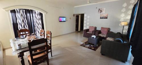 a living room with a couch and a table at Sunshinee Villa in Pune