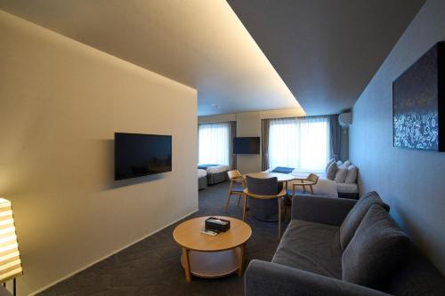 a living room with a couch and a table at Kyohotel Kishotei Goshominami in Kyoto