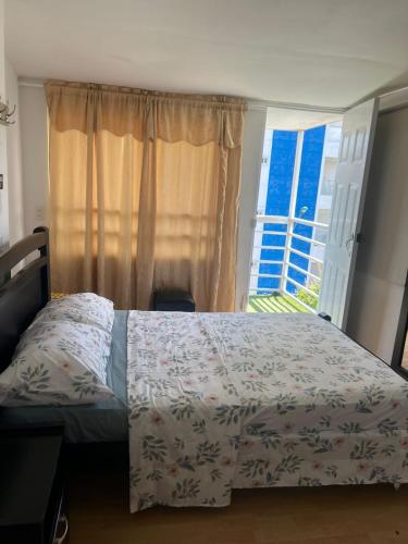a bedroom with a bed in front of a window at JARDIN DE TEQUENDAMA HOTEl in Cali