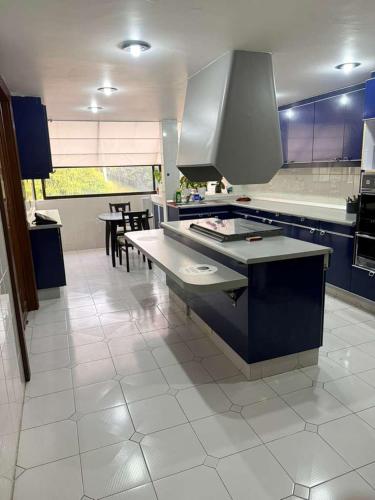 a kitchen with blue cabinets and a white tile floor at Gran Muralla Interlomas in Mexico City