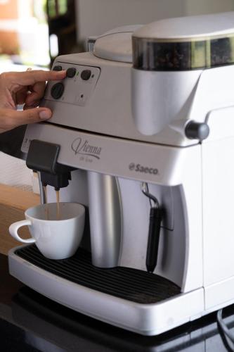 a person is making a cup of coffee in a coffee maker at VILLA DIVA STAR in Ko Yao Noi