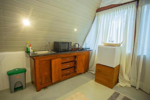 a small kitchen with a sink and a microwave at River Bend Nook in Ahangama
