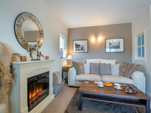 a living room with a couch and a fireplace at The Paddock in Bodelwyddan