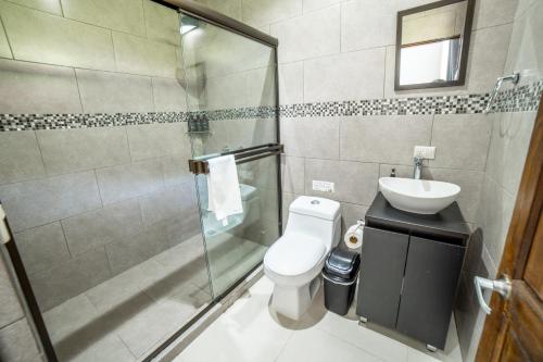 a bathroom with a shower and a toilet and a sink at Natüra Hotel Monteverde in Monteverde Costa Rica