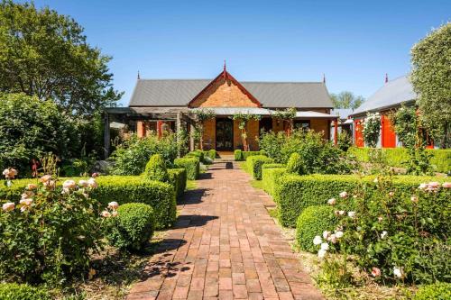 a garden with a brick path leading to a house at Miss Martinellis in Beechworth