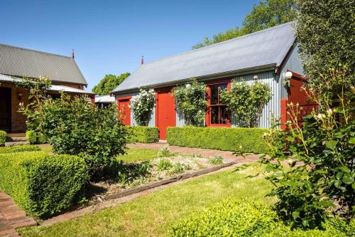 a red house with a garden in front of it at Miss Martinellis in Beechworth
