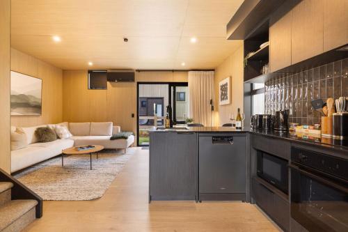a kitchen and a living room with a couch at Rere Villa Queenstown in Queenstown