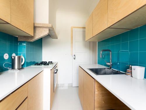 una cucina con lavandino e piastrelle blu di WHome | Damasceno Contemporary Apartment #59 a Lisbona