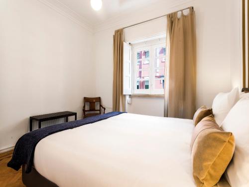 ein Schlafzimmer mit einem weißen Bett und einem Fenster in der Unterkunft WHome | Damasceno Contemporary Apartment #59 in Lissabon