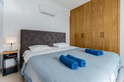 a bedroom with a large bed with blue pillows on it at Seaview Sanctuary House in Larnaca