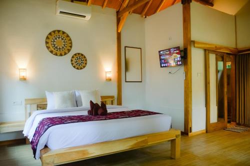 a bedroom with a bed with a teddy bear on it at Beda gaya ecolodge Rangsot 3 in Tanjung