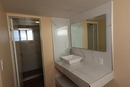 a bathroom with a sink and a mirror at Hotel El Ejecutivo Tijuana in Tijuana