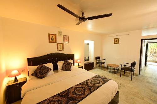 a bedroom with a large bed with a ceiling fan at Perth villa in Mount Ābu