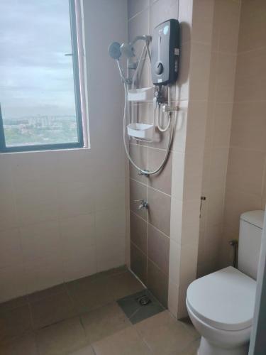 a bathroom with a shower with a toilet and a window at CeeJay Suites in Penampang