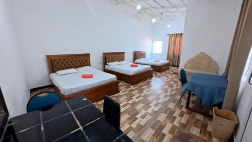 a room with two beds and a table and chairs at Shehan's Hotel Maharagama in Maharagama