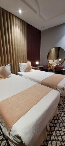 a hotel room with two beds and a mirror at سهول بارك in Riyadh