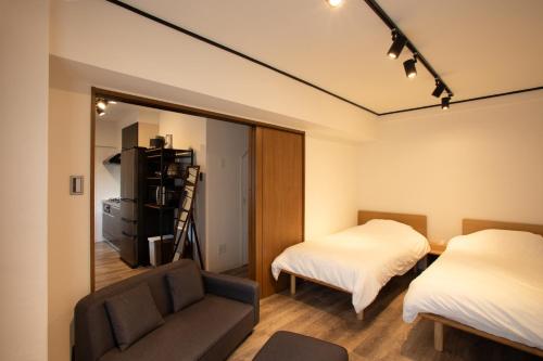 a bedroom with a mirror and a bed and a couch at LUCKY house53 in Tokyo