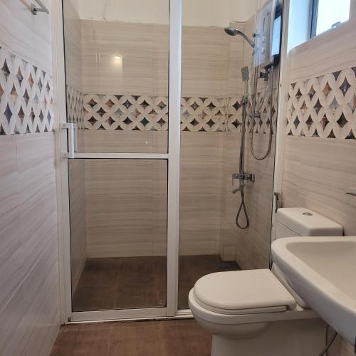 a bathroom with a shower and a toilet and a sink at Hatton Nottingham Villa in Hatton