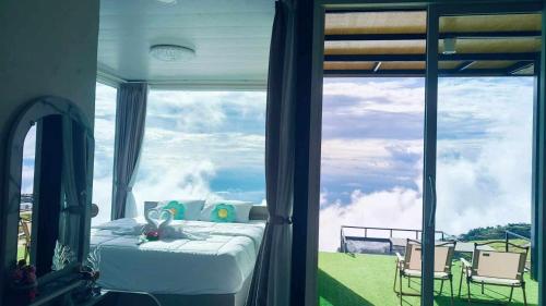 a bedroom with a bed and a large window at หลงใหล ภูทับเบิก in Ban Maeo Thap Boek