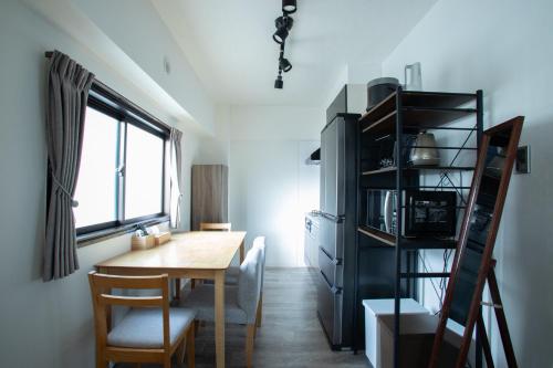 a dining room with a table and a microwave at LUCKY house53 in Tokyo