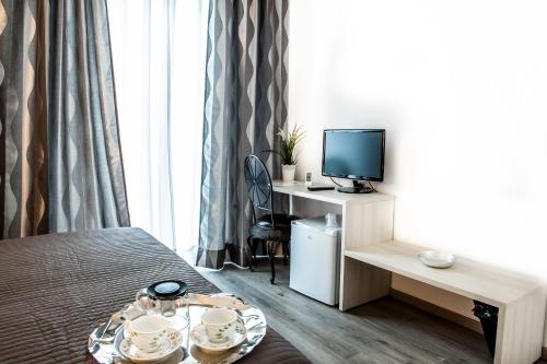 テルモリにあるVenere Roomsのベッドとテレビ付きの机のある部屋
