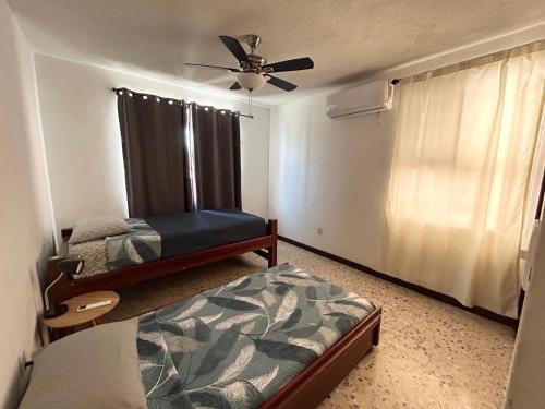 a bedroom with two beds and a ceiling fan at Comfortable apartment 10 min BBVA Stadium - Wi-fi Parking SmartTV & AC in Monterrey