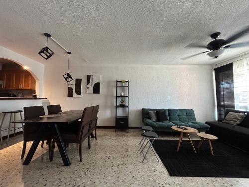 a living room with a green couch and a table at Comfortable apartment 10 min BBVA Stadium - Wi-fi Parking SmartTV & AC in Monterrey
