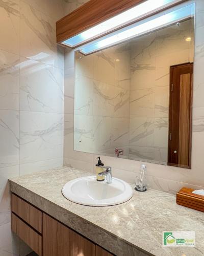 a bathroom with a sink and a large mirror at Casa Verde Guest House in Sempidi