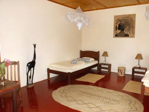 a living room with a table and a giraffe on the wall at Meru Mbega Lodge in Usa River