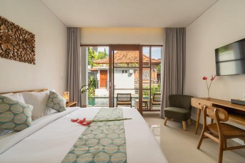 a bedroom with a bed and a desk and a desk at Amantra Ubud in Ubud