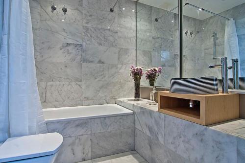 uma casa de banho com uma banheira, um WC e um lavatório. em Apartment Barcelona Rentals - Gracia Pool Apartments Center em Barcelona