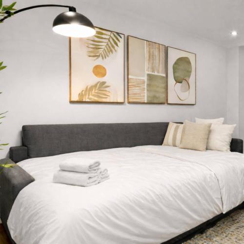 a bedroom with a large white bed with four pictures on the wall at Hip NYC Hideaway in Lively East Village in New York