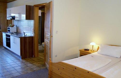 a small bedroom with a bed and a kitchen at Gästehaus Zum Stehling in Monschau