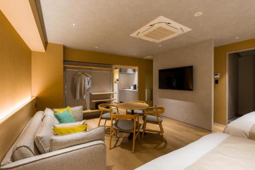 a hotel room with a couch and a table at Sumu Ueno East in Tokyo