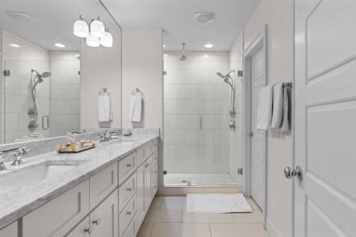 a white bathroom with two sinks and a shower at Private Compound in Decatur in Decatur