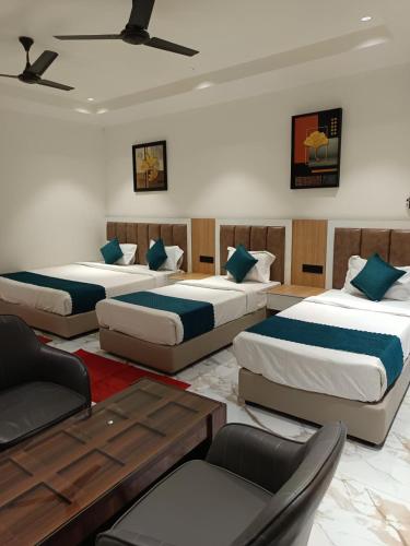 a hotel room with three beds and a table at Rudram Inn in Varanasi